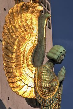 a gold statue on the side of a building