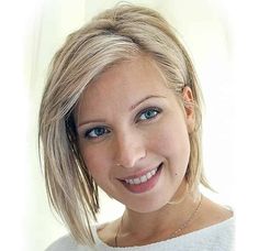 a woman with blonde hair and blue eyes smiles at the camera while wearing a white sweater