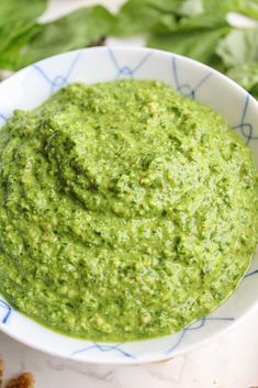 a white bowl filled with green pesto