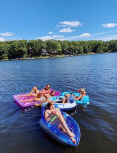 several people are floating on inflatable rafts and having fun at the lake