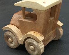 a wooden toy car on a black surface