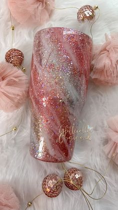 a pink and silver glitter tumbler sitting on top of a white fur covered floor