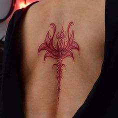 a woman's back with a tattoo design on her left shoulder and lower back