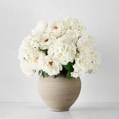 a vase filled with white flowers on top of a table