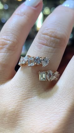 a close up of a person's hand with a ring on it and two diamonds in the middle