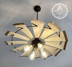 a chandelier hanging from the ceiling with light bulbs on it's sides