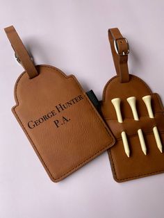 two brown luggage tags with white handles and long ivory nails on the front one has a tag that says george hunter pa