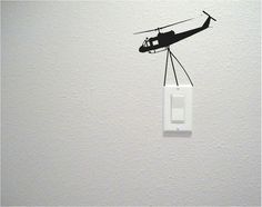 a wall mounted light switch with a helicopter on it