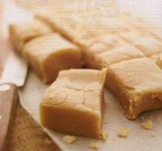 pieces of peanut butter fudge sitting on top of a cutting board next to a knife