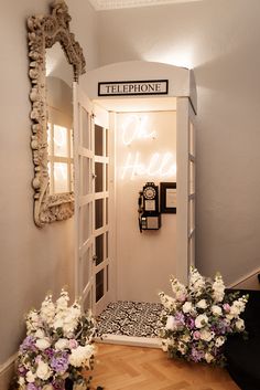 an open door leading into a room with flowers on the floor and a mirror above it