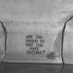 a message is displayed on a screen in front of a television monitor that reads are you proud of who you have become?