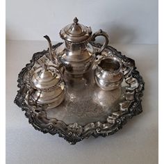 a silver tea set sitting on top of a metal tray