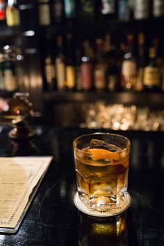 a glass of alcohol sitting on top of a table