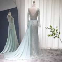 two dresses are on display in front of a white curtain and one is wearing a light blue gown