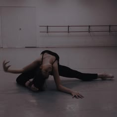 a woman in black shirt doing a handstand on the floor