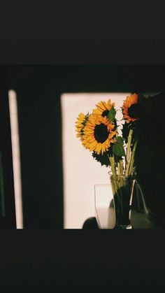 two sunflowers in a vase sitting on a table