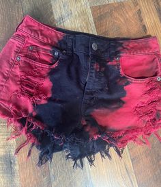 American Eagle black jean cutoffs.  The cutoffs have been over-dyed with red on the sides to provide a striking contract.  Add to that the distressed details and you've got a winner.  These cutoffs will quickly become your favorites, just in time for summer.  Who's in? #distressed #cutoffs #shortsandflipflops #summerfun #blackdenim #americaneagle #tiedye DETAILS Size: 6 w/ some stretch Color: black denim Details:  Frayed hems, distress details, black denim w/ red-dye detials OUR GUARANTEE If for Edgy Cotton Jean Shorts With Frayed Hem, Distressed Cutoff Bottoms For Festival, Edgy Cutoff Cotton Jean Shorts, Edgy Red Cotton Bottoms, Casual Red Bottoms With Frayed Hem, Punk Style Cutoff Cotton Shorts, Punk Style Cotton Cutoff Shorts, Grunge Style Cutoff Cotton Shorts, Cotton Red Shorts For Festival