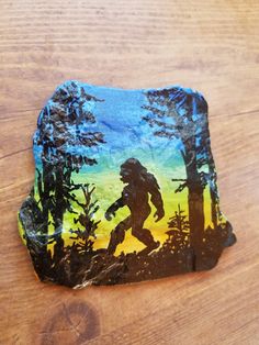 a piece of paper with a painting of a bigfoot in the woods on it