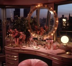 a vanity with flowers and candles on it in front of a large window overlooking the city