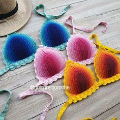 three crocheted bras with hats on the floor