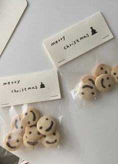 some cookies are wrapped in plastic and have faces drawn on them with words merry christmas