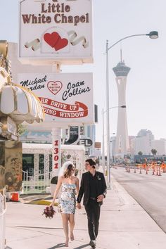 a man and woman walking down the sidewalk in front of a store called little white chapel