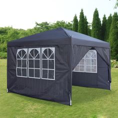 two black tents sitting on top of a lush green field