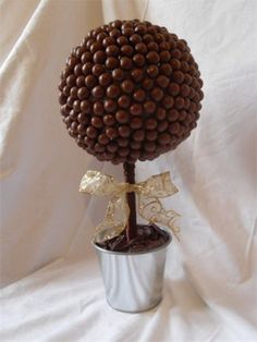 a vase filled with chocolate covered balls on top of a white table