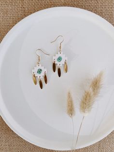 "The clay pieces are an ivory / white color in a sandpaper-like texture. The turquoise stones are authentic and the charms are brass. They are approximately 2\" in length, lightweight and handmade! *FREE EARRING BONUS*: Every order $20+ receives a free pair of earrings of the shop's choice! *FREE SHIPPING*: Use code \"FREESHIP50\" for free shipping on orders $50+. For customizations: Please feel free to message the shop. We cannot always guarantee this as an option, but it never hurts to ask. Pr White Beaded Pierced Earrings For Gift, Nickel-free White Bohemian Chandelier Earrings, White Bohemian Nickel-free Chandelier Earrings, Bohemian White Nickel-free Chandelier Earrings, Nickel Free White Bohemian Earrings, Nickel-free White Bohemian Earrings, Bohemian Nickel-free White Earrings, Bohemian White Nickel-free Earrings, Bohemian Style White Single Earring