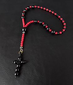 A unique one decade rosary that is shaped around the base of red and black; representing the colors of the Cardinal and the seriousness of one's pure faith and responsibility towards others. Created purely from Black Onyx, Red Corals and a gemstone black cross, the rosary is meant to accompany you during your darkest hours and to strengthen your faith. Additional Uses: When time is not a luxury of yours and yet you wish to dedicate a prayer, a one decade rosary is what you need to have at your d Red Spiritual Jewelry With Black Beads, Spiritual Red Jewelry With Black Beads, Black Rosary With 108 Beads As Gift, Handmade Red Rosary With Cross, Handmade Red Rosary, Handmade Red Cross Rosary, Handmade Black Rosary Gift, Spiritual Black Rosary With 108 Beads, Black Crucifix Rosary Bracelet As Gift