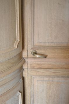 a close up of a door handle on a wooden cabinet