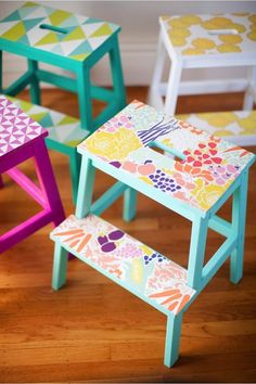 three colorful children's stools sitting on top of a wooden floor next to each other