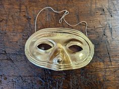 Vintage plastic Halloween gold colored half mask great for wearing and scaring. Overall good condition. Unmarked. Measures 7 inches wide by 4 inches tall. Elastic strap is stapled on but stretched out. PLEASE see photos and video. Great for a party, trick or treating, dress up, or holiday decorating. NOT a medical mask. Previously owned. SOLD AS IS Gold Costume Masks For Halloween, Gold Mardi Gras Mask Costume Accessories, Gold Masks For Halloween Costume Party, Vintage Gold Masks For Costume Party, Mardi Gras Costume Accessories In Gold, Vintage Gold Masks And Prosthetics For Masquerade, Vintage Gold Masks And Prosthetics For Costume Party, Gold Halloween Costume Mask, Gold Mardi Gras Costume Accessories