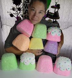 a woman is holding several different colored marshmallows