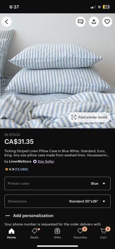 a bed with blue and white striped pillows on it's side, next to a phone