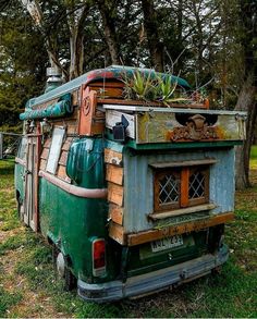 an old camper van with plants growing out of it's roof is parked in the grass