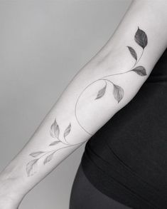 a woman's arm with leaves on it