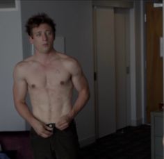 a man without a shirt standing in a room