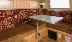 the inside of a camper with a table and couches in front of it