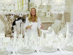 a woman standing in front of a table with white decorations