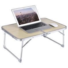 an open laptop computer sitting on top of a folding table