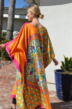 Make your day shine in this gorgeous, designer print silk caftan. Vibrant colors of orange, fuchsia and greens in a unique and special combinations of patterns with hints of gold embellishment throughout the pattern. A stunning garment for any occasion. Opaque fabric with no need of undergarment. One size. Fits medium to X-Large . Can be worn by many sizes. The width is 54 inches wide, edge to edge, or 108 inches around the body. The length is 52 inches. The side seams are 7 inches from the edge Orange Kaftan With Kimono Sleeves For Spring, Orange Maxi Length Kaftan For Spring, Silk Multicolor Print Kaftan For Vacation, Orange Printed Kaftan For Vacation, Orange Spring Kaftan With Kimono Sleeves, Vibrant Print Kaftan For Vacation, Orange Tunic Kaftan For Beachwear, Multicolor Silk Kaftan For Beachwear, Orange Tunic Kaftan For Festivals