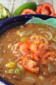 a blue bowl filled with soup and vegetables