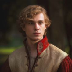 a young man with curly hair wearing a red collared shirt