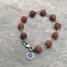 "Lovely Rudraksha Seed Beads wrapped in oxidized sterling silver with a Hilltribe fine silver OM charm. This beaut is 7 1/4\" and closes securely with a sterling silver lobster clasp. Rudraksha is worn at all times or kept close to the skin, it is a sacred seed that emits a potent protective energy, enabling the wearer to achieve their greater potential." Rudraksha Bracelet, Protective Energy, Om Charm, Beaded Wraps, Silver Chain Bracelet, Huntington Beach, Prayer Beads, Oxidized Sterling Silver, Sterling Silver Bracelet