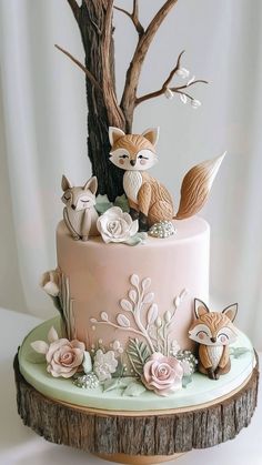 a pink cake decorated with foxes and flowers