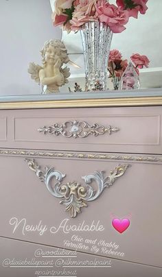 a pink dresser with flowers in a vase on top