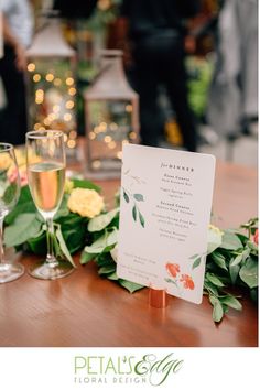 a table with wine glasses and menu on it