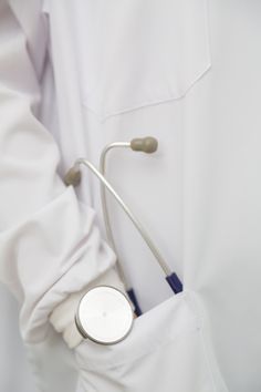 a person in white lab coat holding a stethoscope