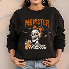 Celebrate Halloween with a playful twist with our "Momster" Sweatshirt and T-Shirt! Featuring a whimsical skeleton mom graphic and the word "Momster," this design is perfect for moms who love to embrace the spooky season with style. Available in both sweatshirt and t-shirt options, this unique piece is a must-have for Halloween festivities. Key Features: Unique Design: Eye-catching skeleton mom graphic with the playful phrase "Momster." Unisex Fit: Multiple sizes available, offering a comfortabl Funny Halloween Graphic Print Sweatshirt, Halloween Crew Neck Sweatshirt With Screen Print, Fun Black Sweatshirt With Graphic Print, Fun Halloween Crew Neck Sweatshirt, Halloween Crew Neck Sweatshirt With Character Print, Halloween Character Print Crew Neck Sweatshirt, Funny Crew Neck Sweatshirt For Halloween, Mom Pride, Quirky Fashion